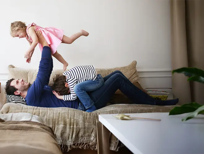 Environnement domestique chaleureux avec un père jouant joyeusement avec sa fille.