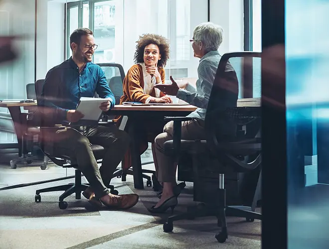Trois experts en gestion d'actifs discutent dans les bureaux d'Amundi.