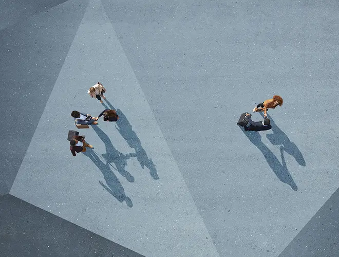Illustration de quatre professionnels discutent dans un bureau moderne d'Amundi, avec des ombres allongées sur le sol.