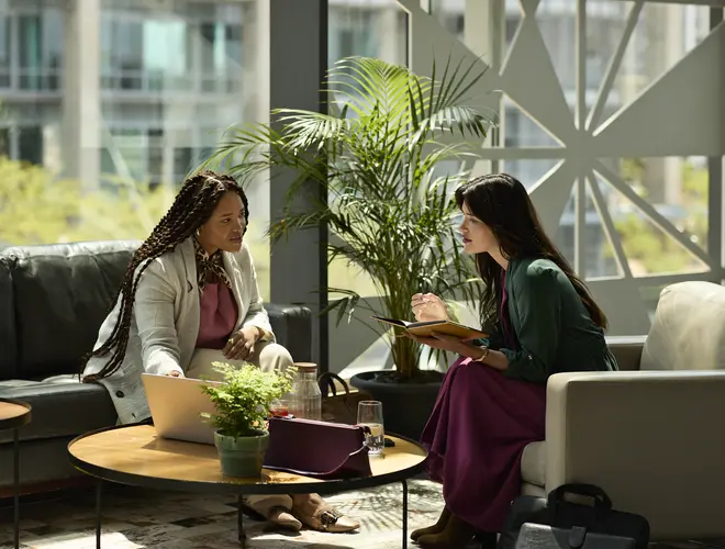 Deux gestionnaires d'actifs échangent dans les bureaux d'Amundi, entourées de plantes.