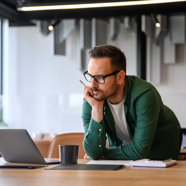 Un expert financier se penche sur son bureau, dans les bureaux d'Amundi, réfléchissant à des stratégies d'investissement.