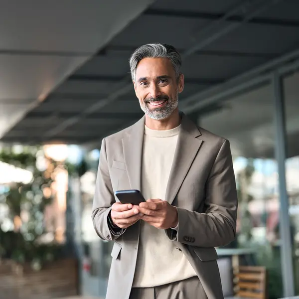 Correspondant entreprise consultant son téléphone pour piloter l'épargne salariale de son entreprise.