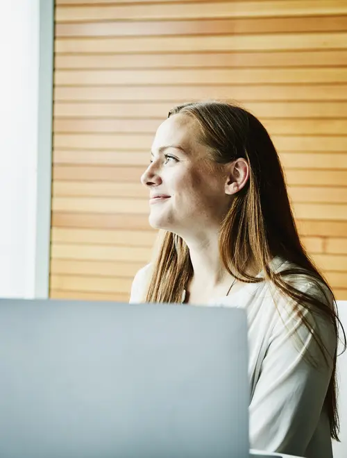 Professionnelle en gestion d'actifs, concentrée devant un ordinateur dans les bureaux d'Amundi.