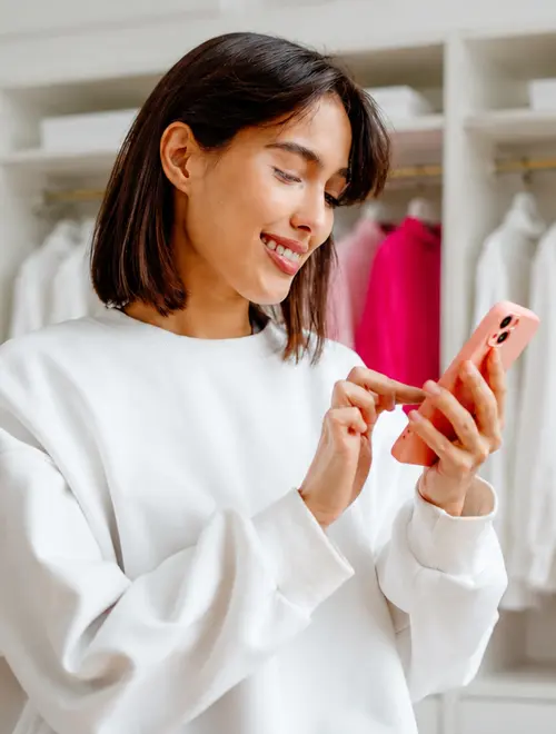 Une experte en finance consulte son téléphone, vêtue d'un sweat blanc, dans un bureau d'Amundi.