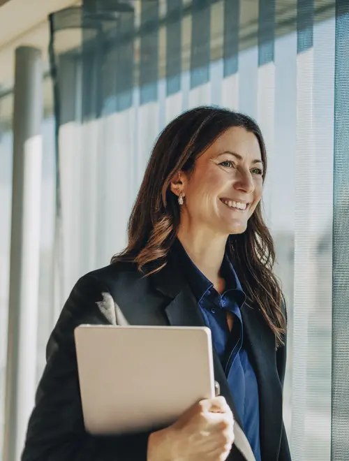 Une gérante dans les bureaux d'Amundi, tenant un ordinateur.
