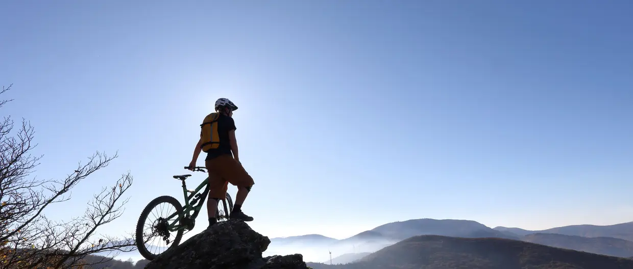 Mountain Biker blickt auf Berge und Windräder