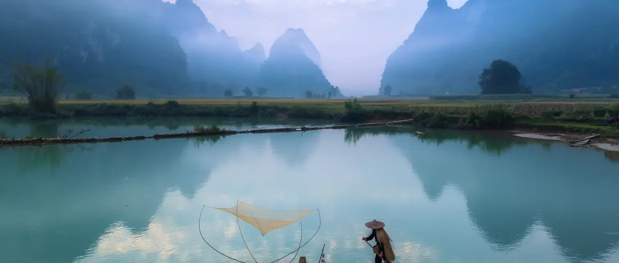 Fischer auf einem Floß beim Fischen in einem Fluss in Nordvietnam