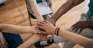 responsible-investment-social-five-people-around-a table-with-a-wheelchair-user
