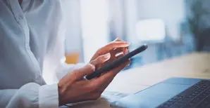 Frau mit Smartphone und Laptop