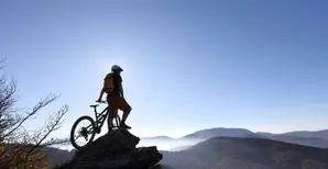 Mountain Biker blickt auf Berge und Windräder