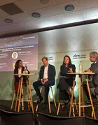 Panel discussion at the PRI in-person event in Amsterdam, with four speakers seated on stools on an Amundi-branded stage. A presentation screen shows “A New Blueprint for Financing the Green Transition in Emerging Markets” and the Global Green Bond Initiative.
