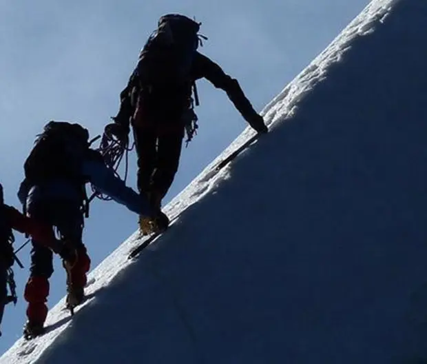three-men-climbing-a-snow-covered-mountain