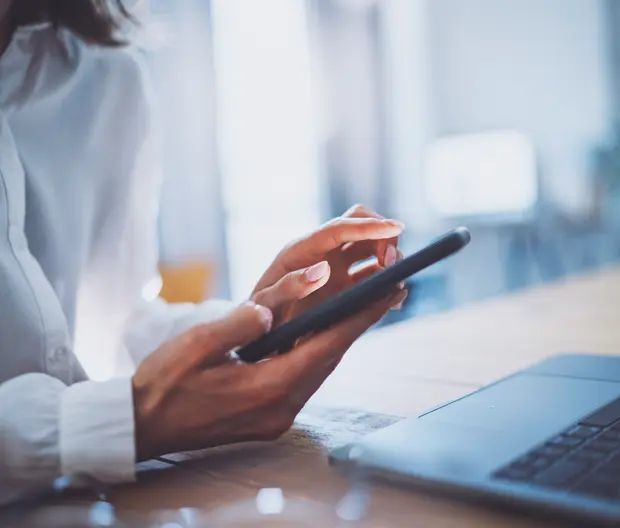Frau mit Smartphone und Laptop