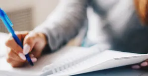 immagine di mano in primo piano che scrive su un'agenda