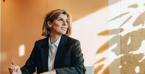donna seduta al desk con lo sguardo rivolto verso l'esterno