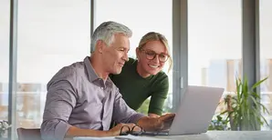 coppia sorridente che lavora al pc
