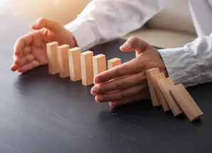 dettaglio di due mani che proteggono caselle domino