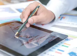 grafici su un tablet e mano che indica con una penna