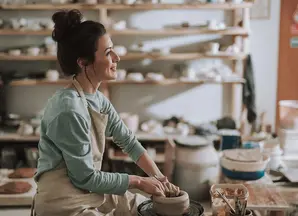 ragazza sorridente che dipinge l'argilla 
