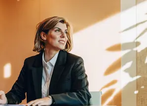 donna seduta al desk con lo sguardo rivolto verso l'esterno
