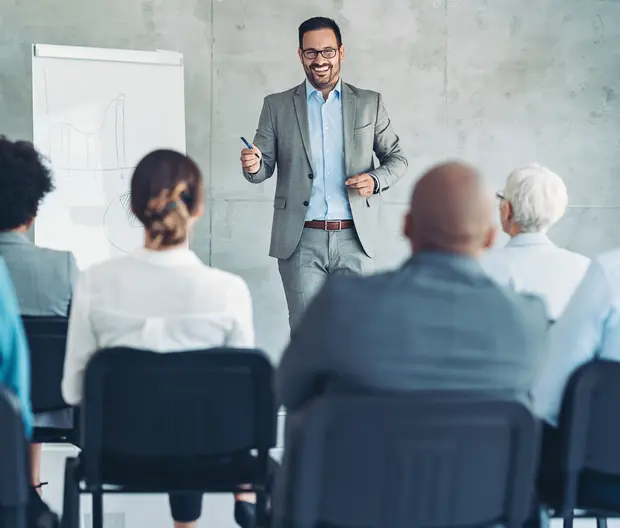 Uomo d'affari che parla ai colleghi in un aula di formazione