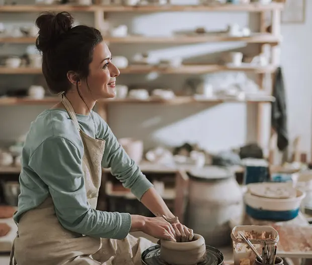 ragazza sorridente che dipinge l'argilla 