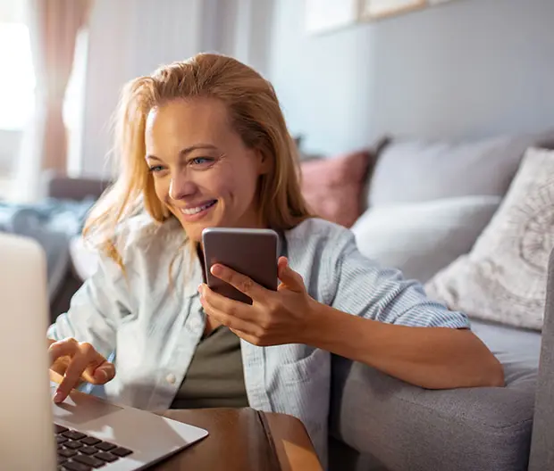 immagine di ragazza sorridente con pc e telefono
