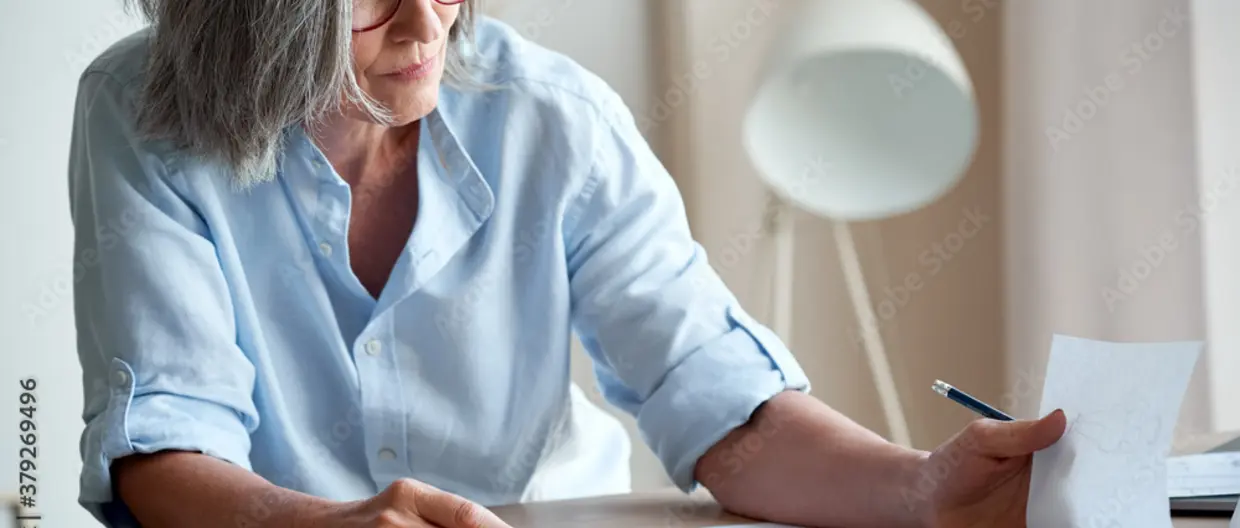 Woman sitting at desk reading papers