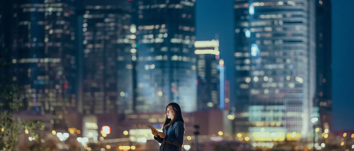 Woman in cityscape at night