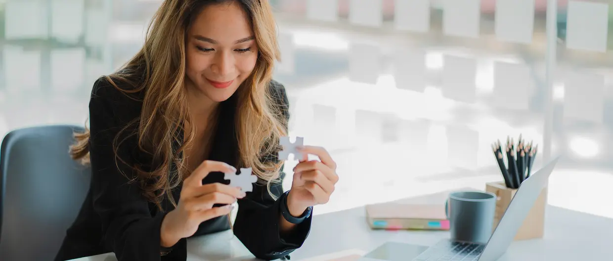 businesswoman finding solution to a jigsaw 