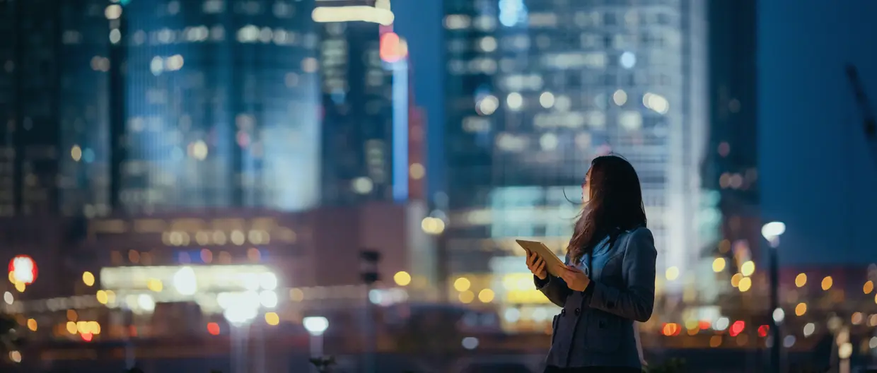 junge Frau mit Tablet vor Skyline