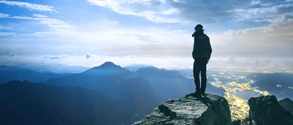 panorama di montagne e persona in primo piano che guarda l&#039;orizzonte