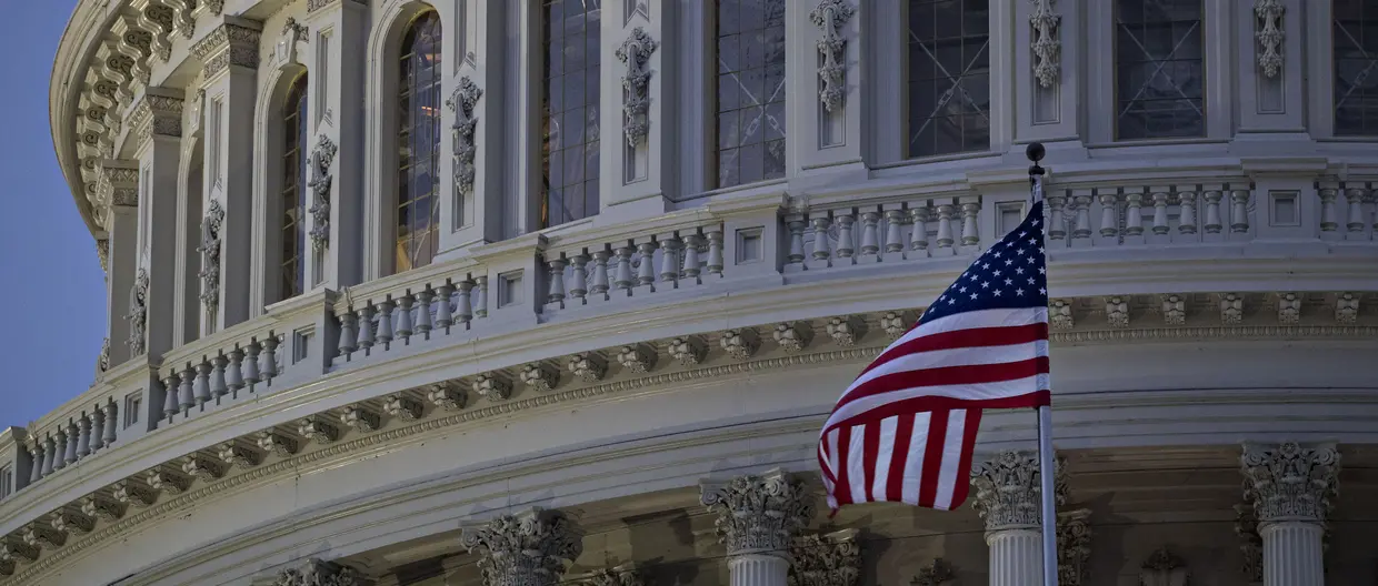 The American flag flies outside the U.S. Capitol before sunrise