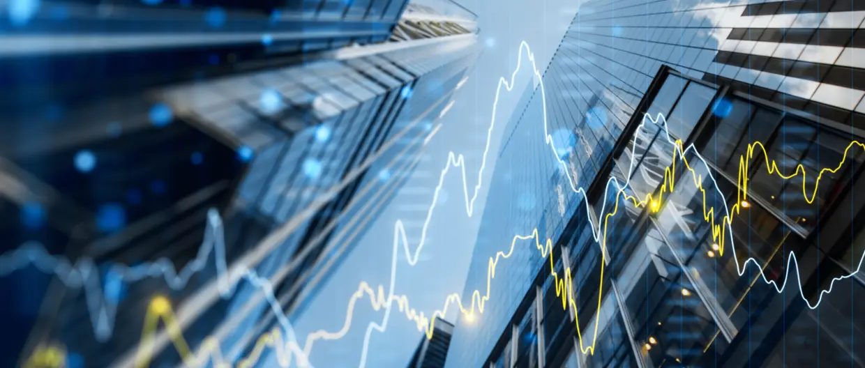 A double exposure image of skyscrapers with overlay of financial graphs, set against a blurred background, illustrating the concept of business growth