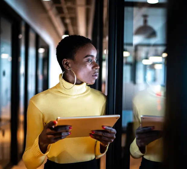Woman in yellow top in office with tablet