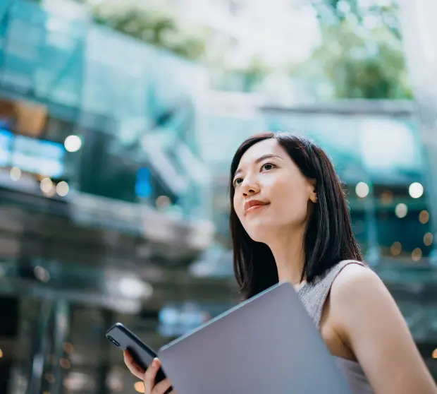 Woman outside office with folder and phone