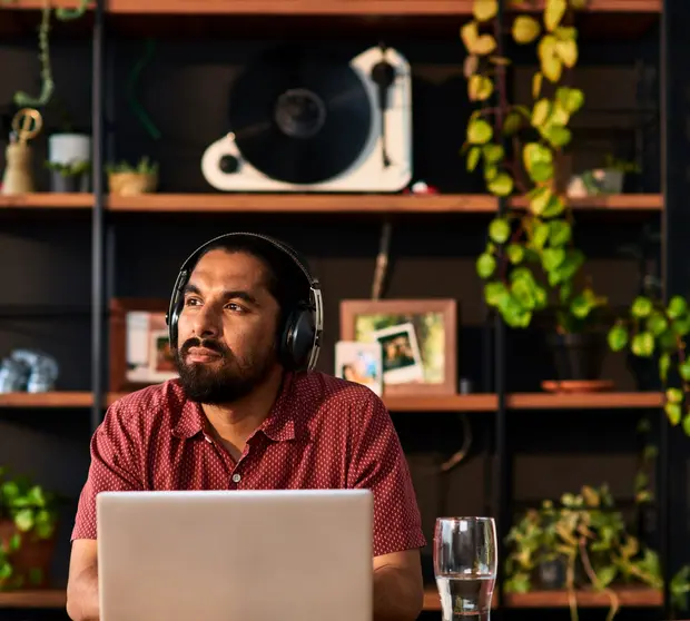 Man on computer with headphones on