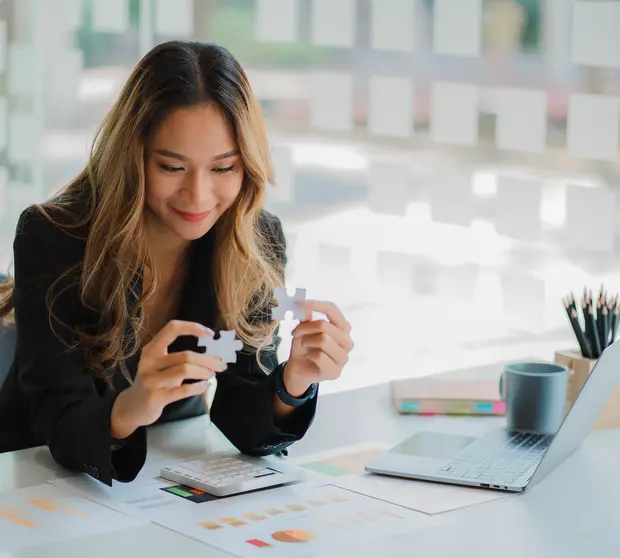 businesswoman finding solution to a jigsaw 