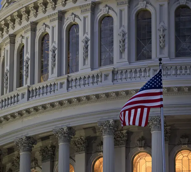 The American flag flies outside the U.S. Capitol before sunrise