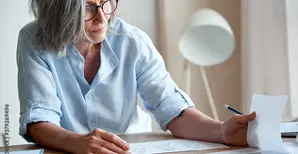 Woman sitting at desk reading papers