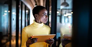 Woman in yellow top in office with tablet