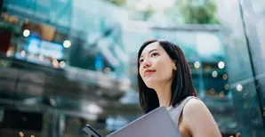 Woman outside office with folder and phone