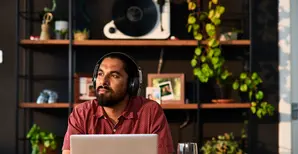 Man on computer with headphones on