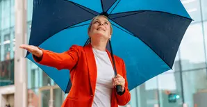 woman with a red jacket under a blue umbrella