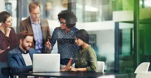 People standing around laptop