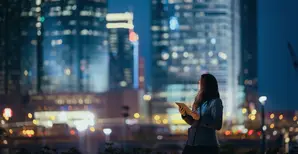 junge Frau mit Tablet vor Skyline