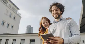 junges glückliches Paar mit Tablet unterwegs