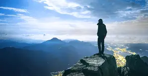 panorama di montagne e persona in primo piano che guarda l&#039;orizzonte