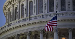 The American flag flies outside the U.S. Capitol before sunrise