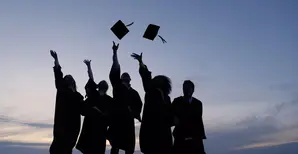 graduating student throwing caps in the air